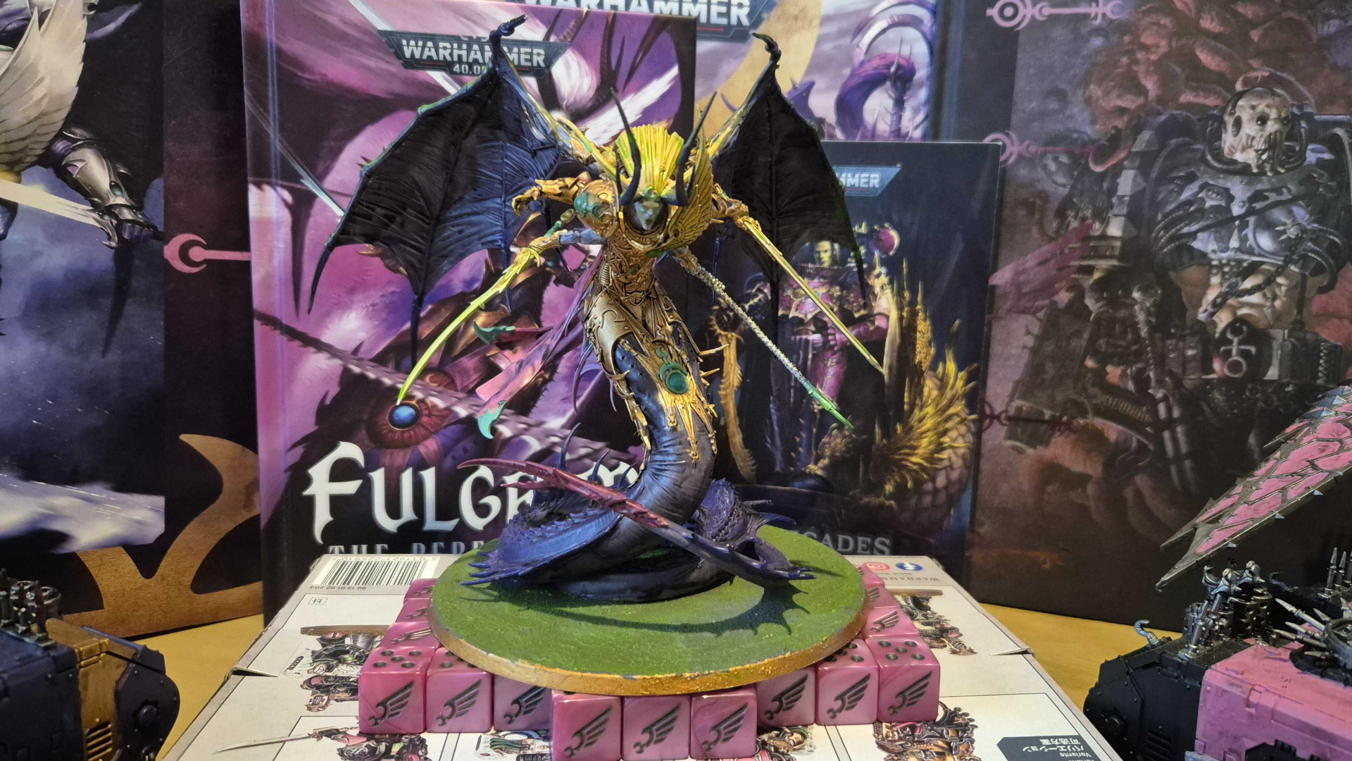 Warhammer 40,000 Fulgrim model on top of Emperor's Children dice, in front of Codexes and artwork for the faction